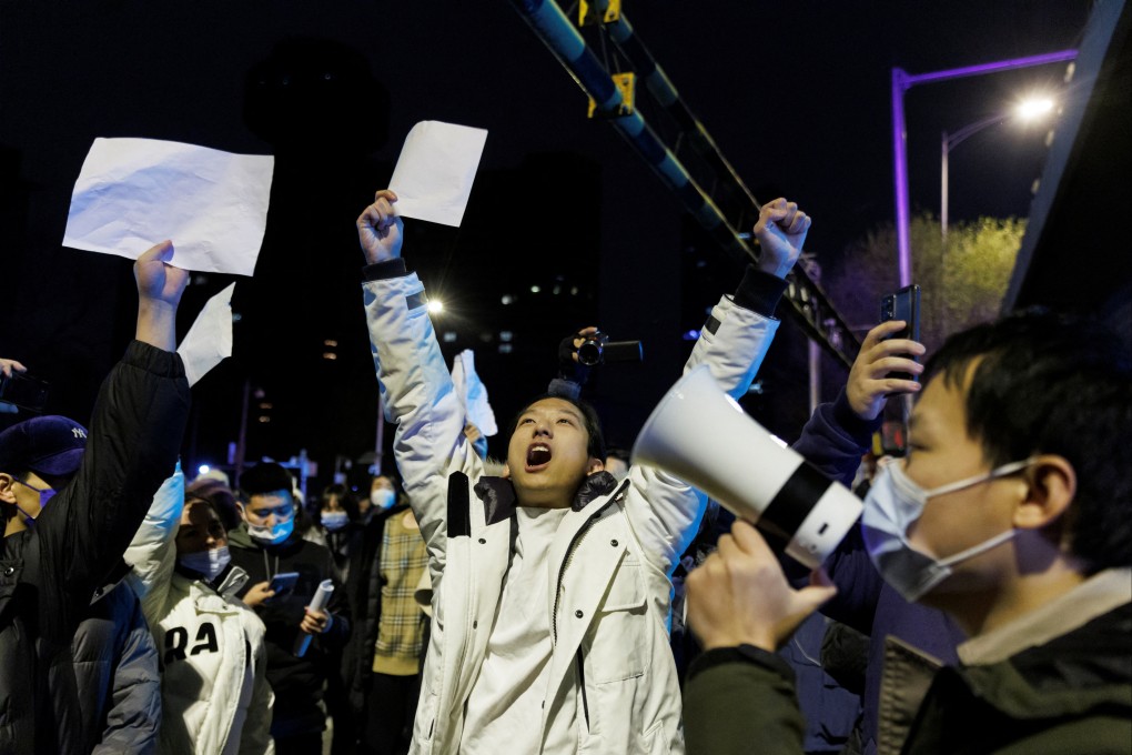 People hold white sheets of paper in protest over restrictions after a vigil for the victims of a fire in Urumqi. Photo: Reuters