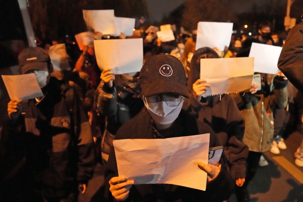 Protesters hold up blank papers and chant slogans as they march in protest in Beijing last Sunday. Photo: AP Photo