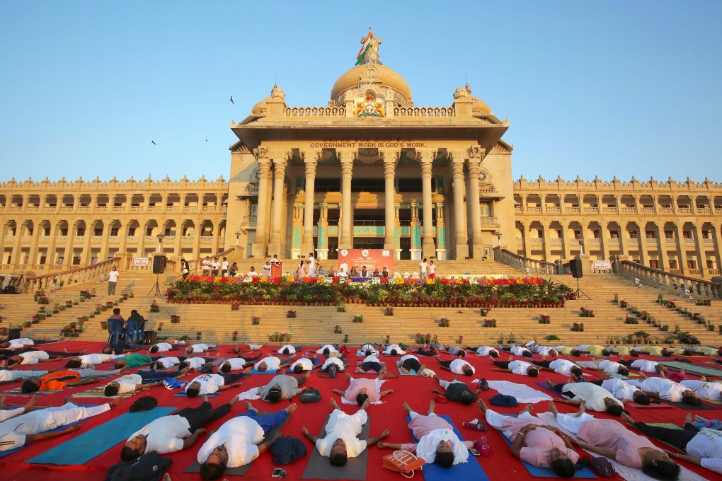 Yoga enthusiasts perform sun salutations in front of the state legislature of Bangalore during a Hindu festival in 2017. Photo: EPA