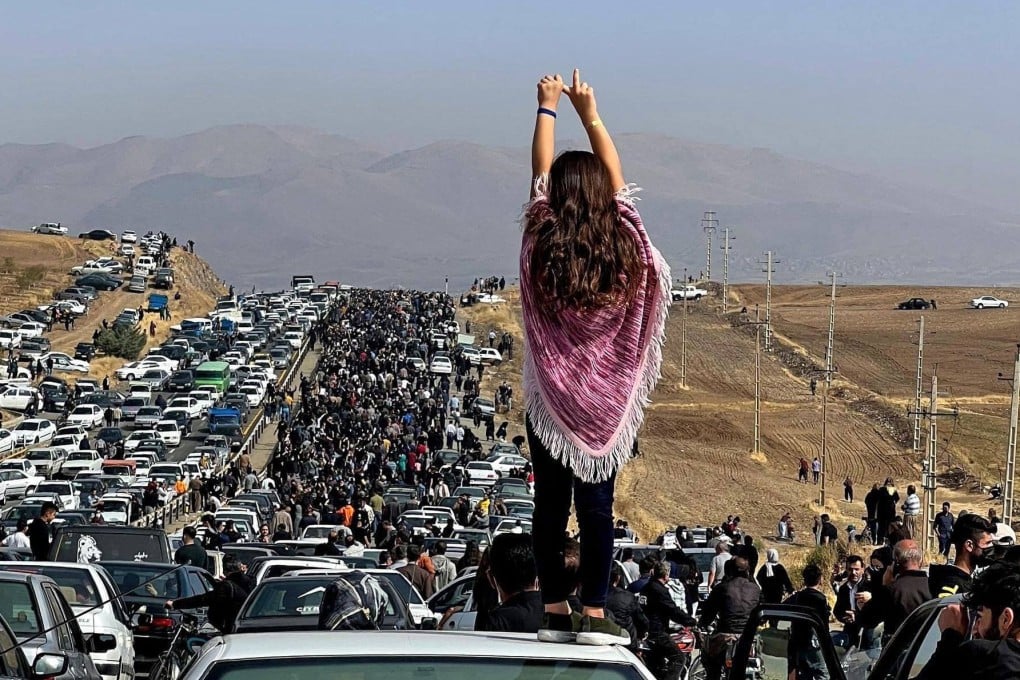 This UGC image posted on Twitter reportedly on October 26, 2022 shows an unveiled woman standing on top of a vehicle as thousands make their way towards Aichi cemetery in Saqez, Mahsa Amini’s home town in the western Iranian province of Kurdistan, to mark 40 days since her death, defying heightened security measures as part of a bloody crackdown on women-led protests. Photo: UGC/AFP