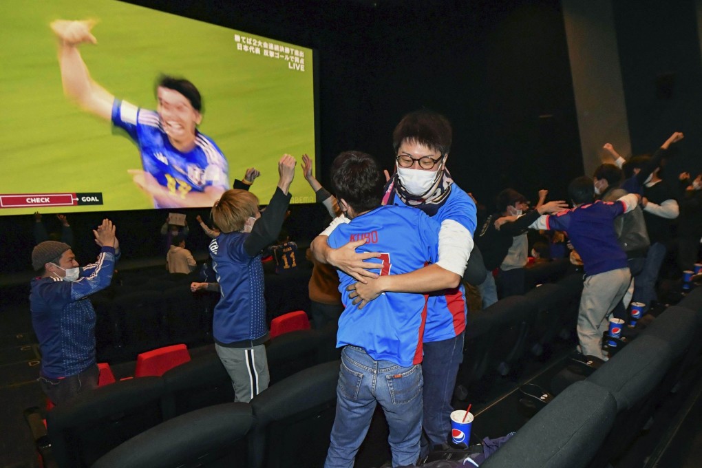 Fans wearing Samurai Blue shirts hug at a public viewing event in Fuchu, Hiroshima Prefecture, western Japan, on Dec. 2, 2022, after Japan’s winning goal against Spain. Photo: Kyodo