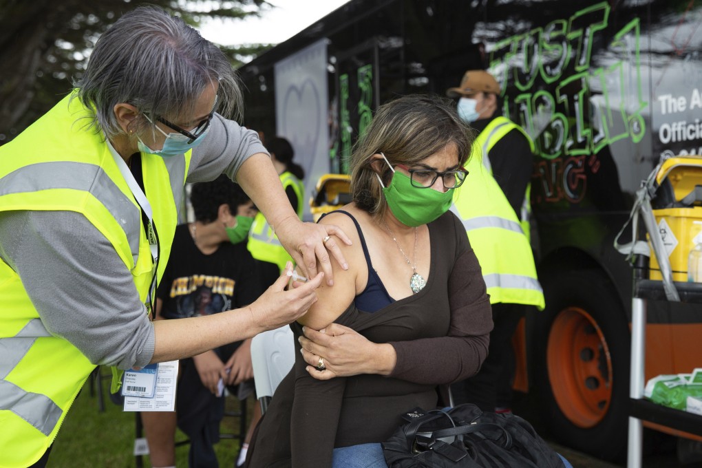 A health worker administers a Covid-19 vaccination to a woman in Auckland, New Zealand, last year. Photo: New Zealand Herald via AP