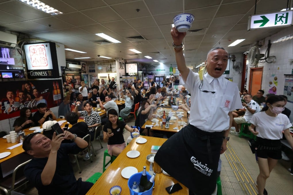 Robby Cheung, co-owner and manager of Tung Po Kitchen, raises a toast at the Java Road Market and Cooked Food Centre in North Point on September 1. Photo: Dickson Lee