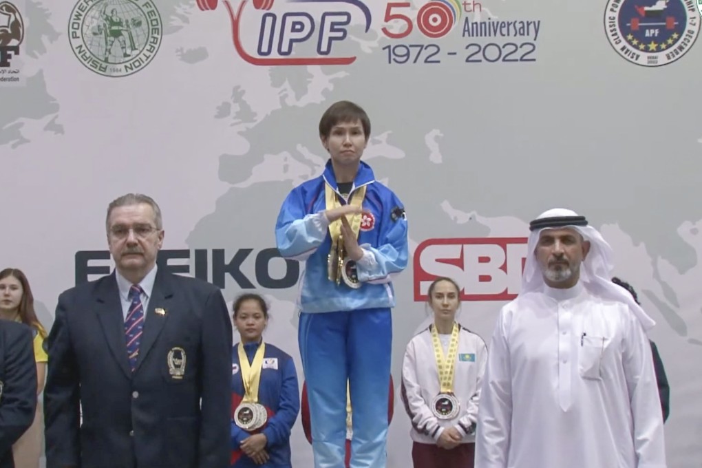 Hong Kong gold medal winner Susanna Lin makes the timeout “T” sign to halt playing of the wrong song during the medals ceremony at the Asian Classic Powerlifting Championship. Photo: YouTube
