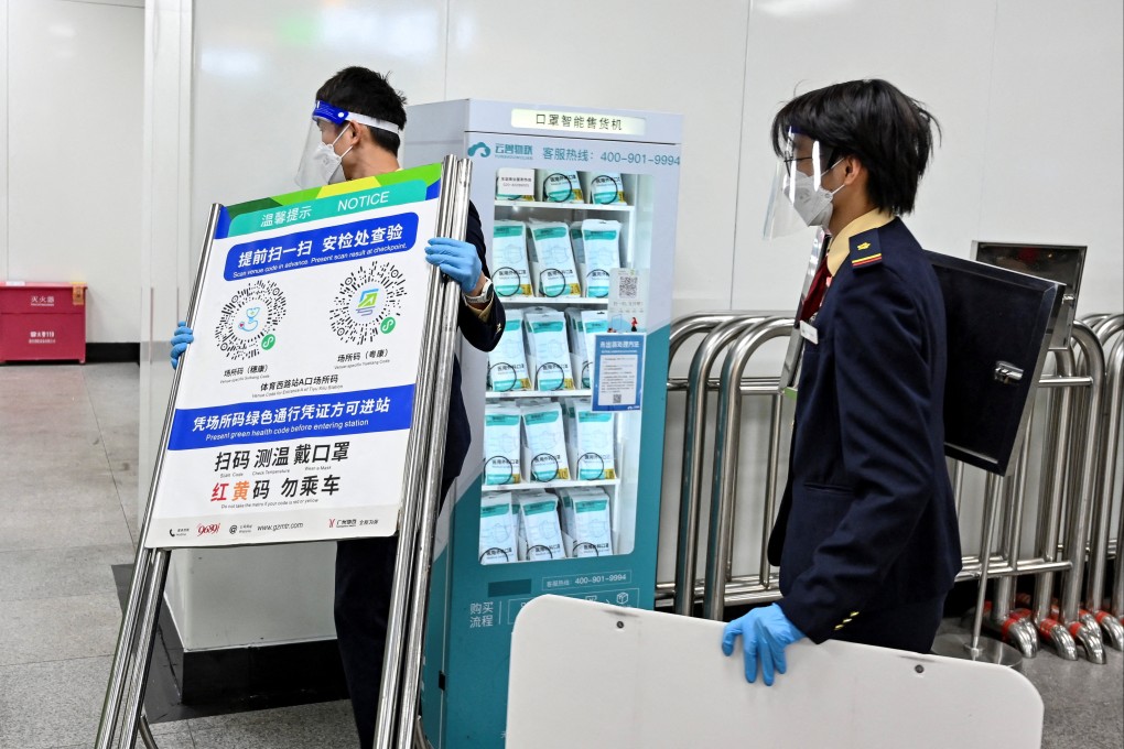 Staff members remove signs guiding people to scan their health code at a subway station in Guangzhou on December 7, 2022, after the government withdrew this Covid-19 control measure. Photo: Reuters