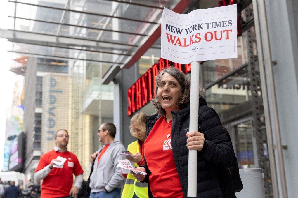 A guild member holds a placard supporting a union walk out, outside the New York Times building in Manhattan on Thursday. Photo: Reuters