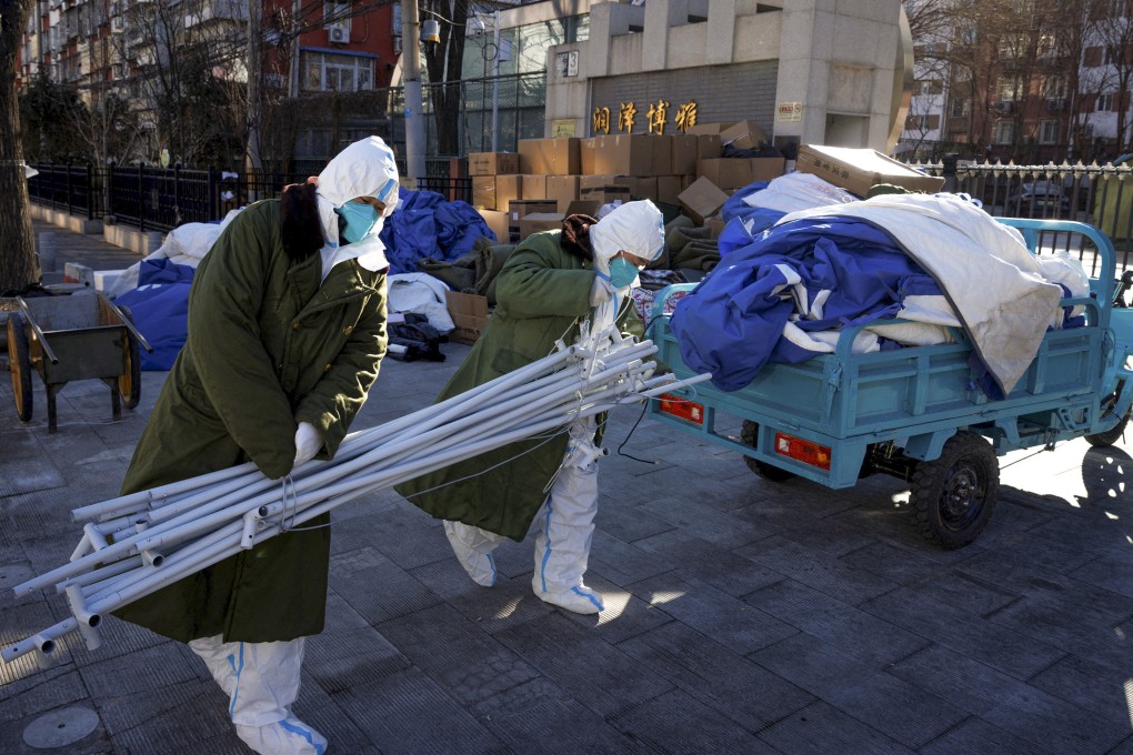 Pandemic control workers in protective suits unload tent poles as they dismantle structures in a neighbourhood that used to be under lockdown in Beijing on Saturday. Photo: Reuters