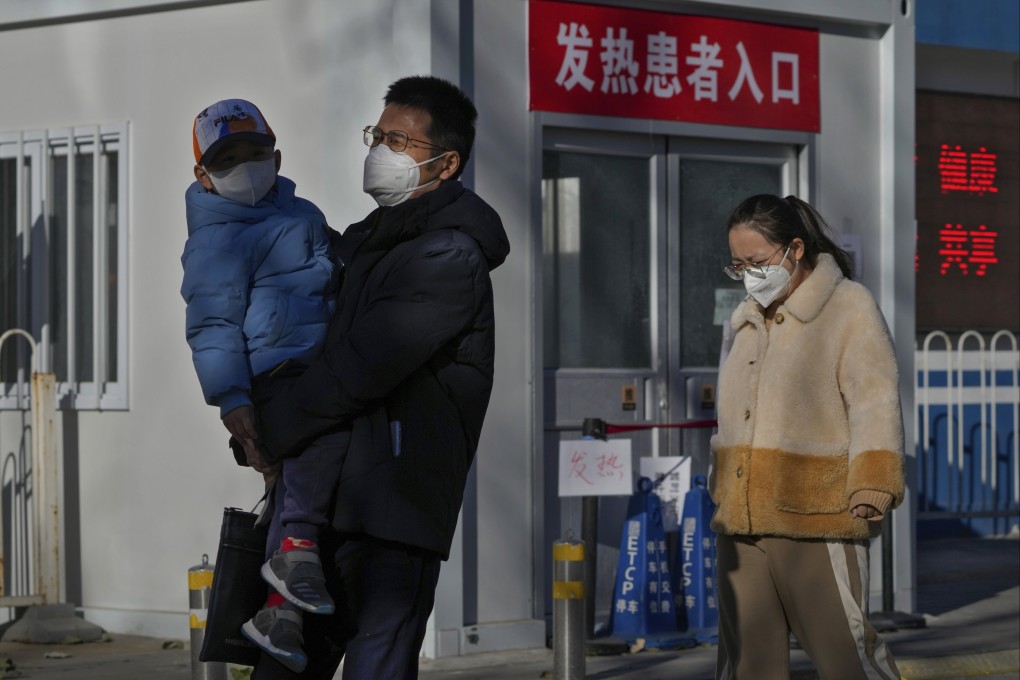 Resident walk by a closed fever clinic at a hospital in Beijing on Sunday. Photo: AP Photo