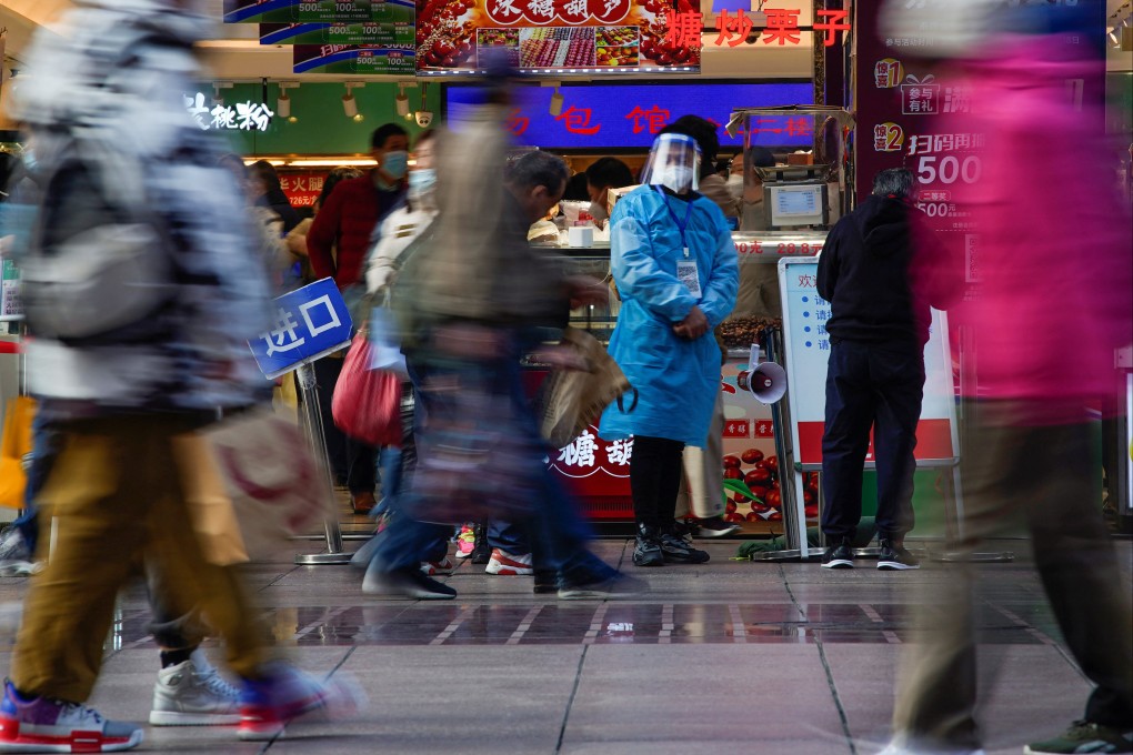 A worker in a protective suit stands at a food shop in Shanghai on December 12. On December 8, China’s State Council issued new guidelines on how to manage and monitor Covid-19 symptoms. Photo: Reuters