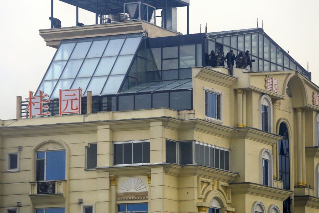 Taliban fighters appear on the rooftop of a hotel building that came under attack in Kabul, Afghanistan, on Monday. Photo: AP