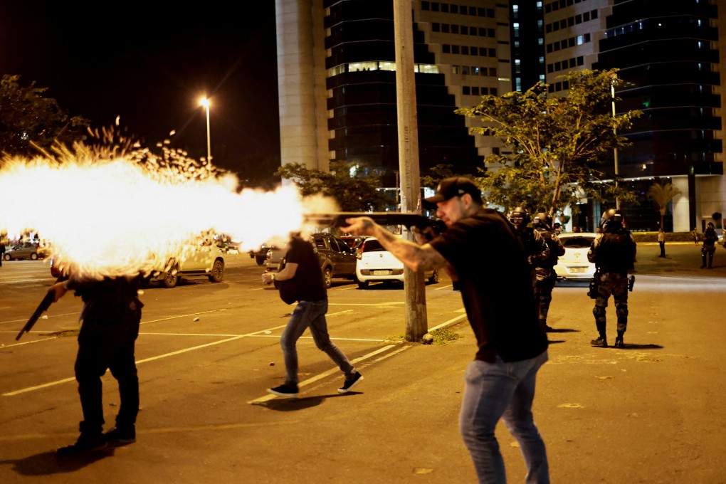 A police officer fires a gun as supporters of Brazil’s outgoing President Jair Bolsonaro protest after a supreme court justice ordered that an indigenous leader be arrested for alleged anti-democratic acts. Photo: Reuters