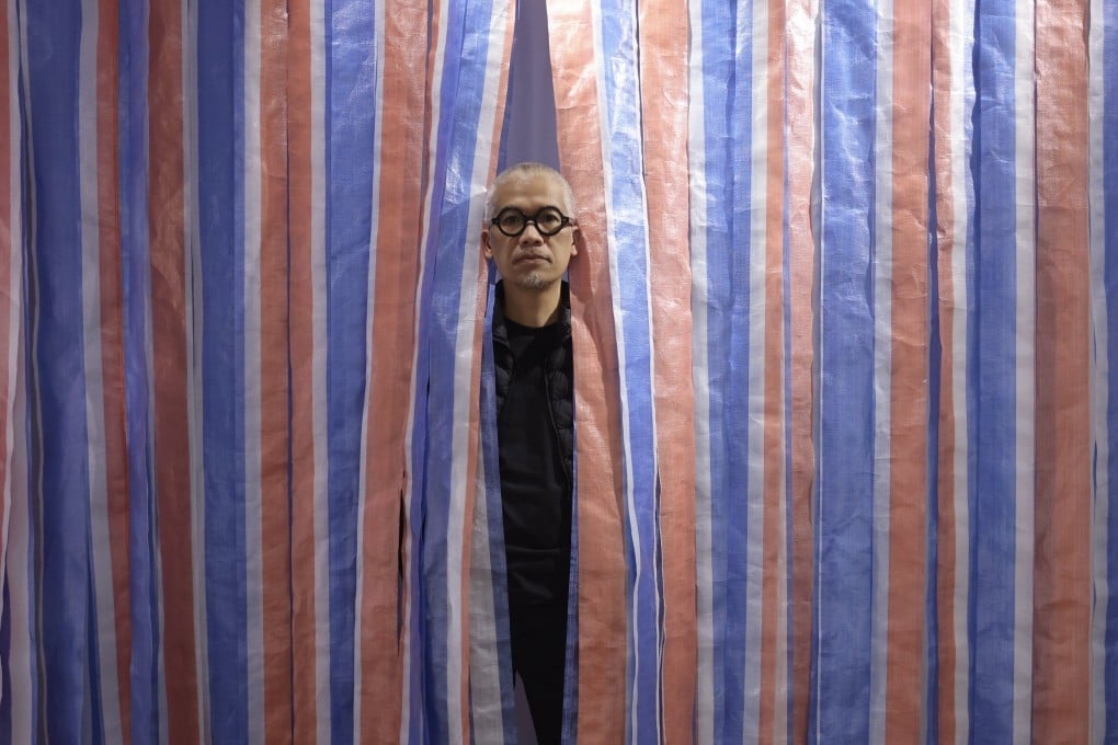 Stanley Wong Ping-pui at his exhibition ‘on hong kong // anothermountainman solo 2022’ at Lucie Chang Fine Arts in Wong Chuk Hang. The artist also known as anothermountainman has long taken inspiration from the red, white and blue canvas material widely used in Hong Kong. Photo: Jonathan Wong