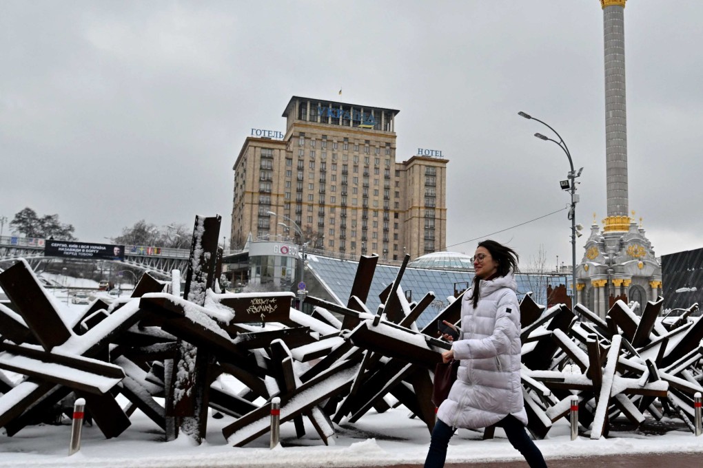 A woman walks past anti-tank steel hedgehogs covered with snow in Kyiv. Photo: AFP