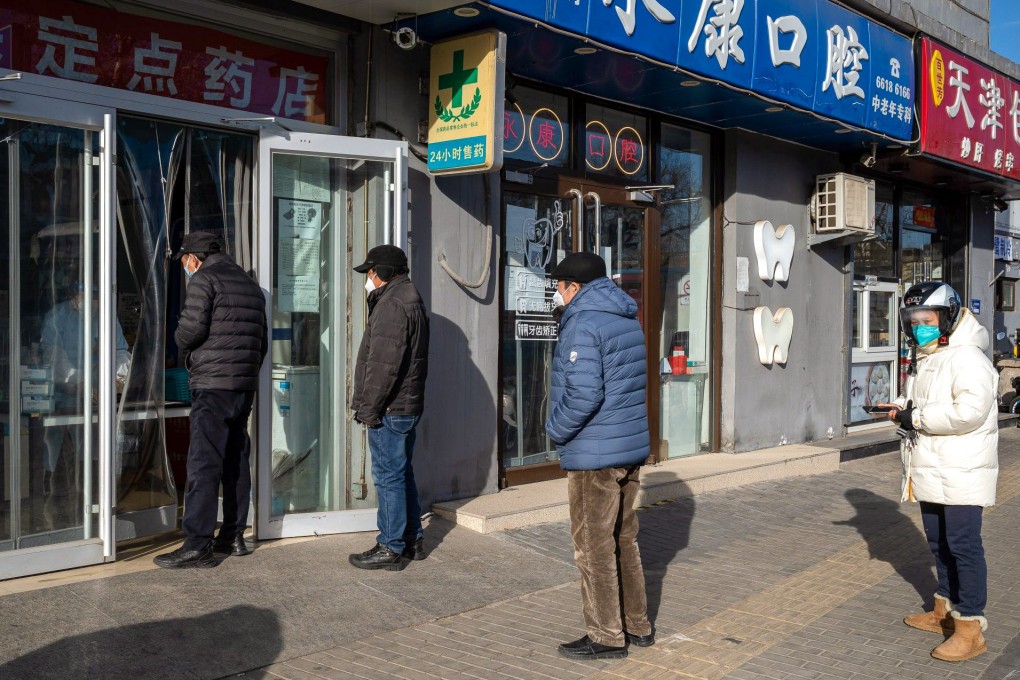Customers queue outside a pharmacy in Beijing to buy medicine on Thursday. A surge in Covid-19 infections has affected sales of lived-in homes in China’s capital as people put of viewings. Photo: Bloomberg