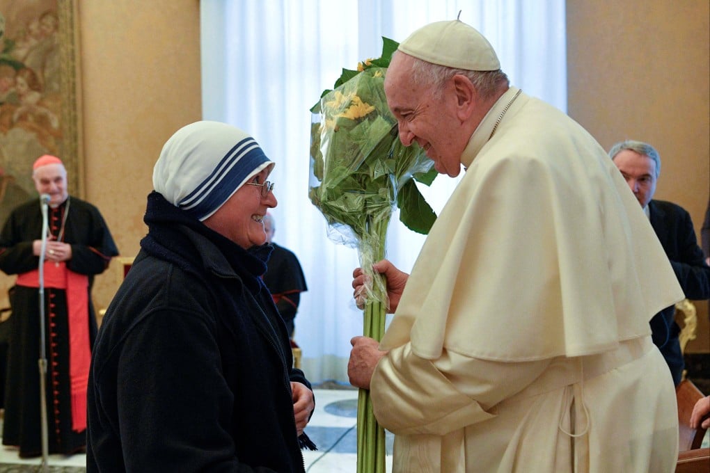 Pope Francis receives flowers from a nun during his 86th birthday celebrations. Photo: Reuters