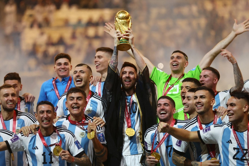 Lionel Messi lifts the World Cup trophy alongside teammates as they celebrate their victory. Photo: Reuters