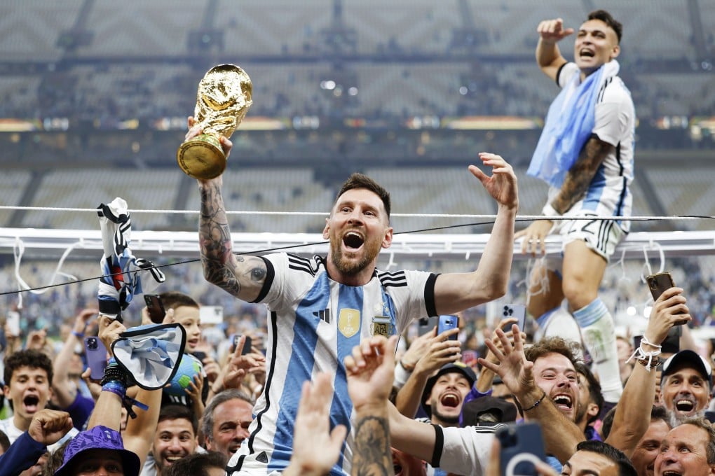 Lionel Messi celebrates while holding the World Cup trophy after his side’s penalty shootout win over France. Photo: Kyodo