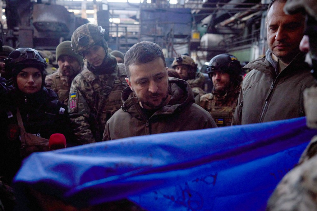 Ukrainian soldiers in Bakhmut give President Volodymyr Zelensky a Ukrainian flag for US President Joe Biden. Photo: Ukrainian Presidential Press Service