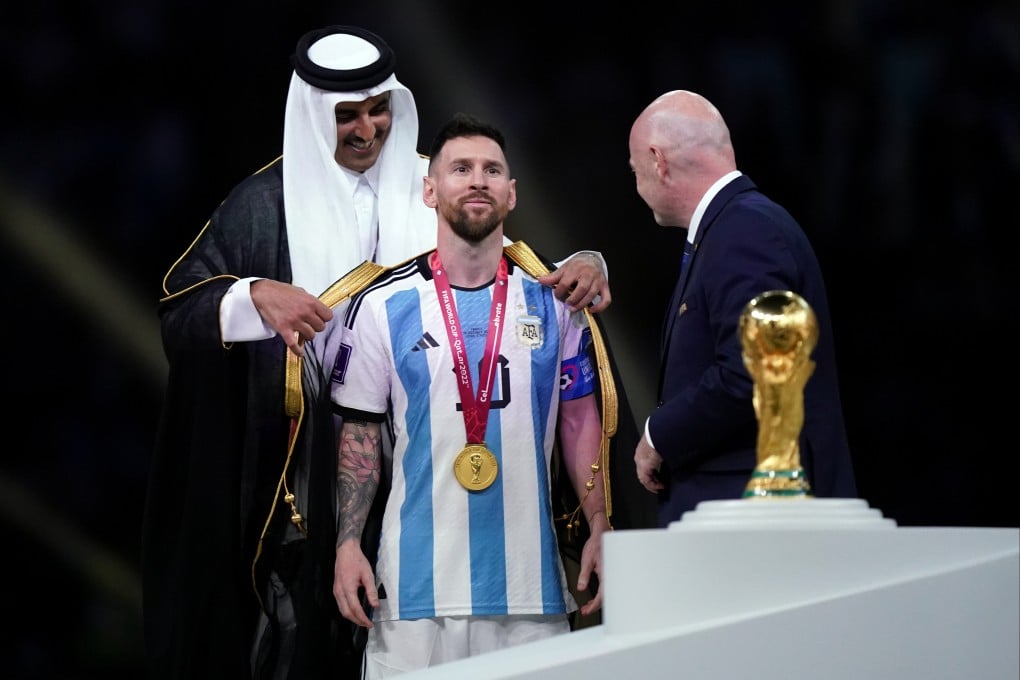 Qatar emir Sheikh Tamim bin Hamad Al Thani covers Argentina’s Lionel Messi in an Arab bisht as Fifa president Gianni Infantino waits to present the winning trophy at Lusail Stadium on December 18. Photo: PA Wire/dpa