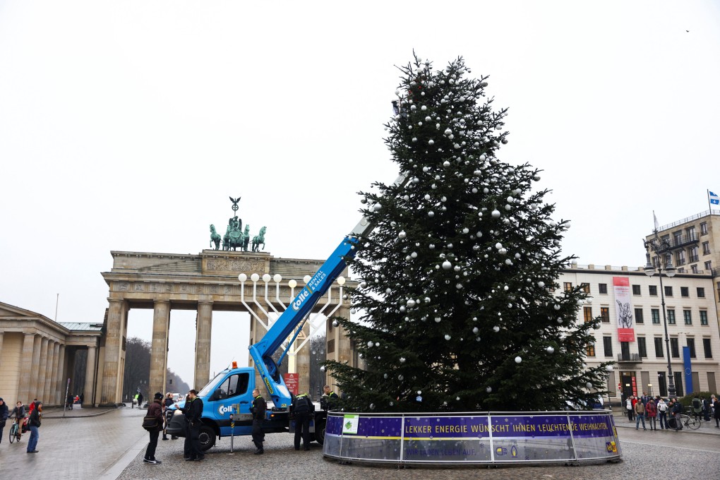 Last Generation activists cut the top off a Christmas tree at Brandenburg Gate, in Berlin, Germany. Photo: Reuters