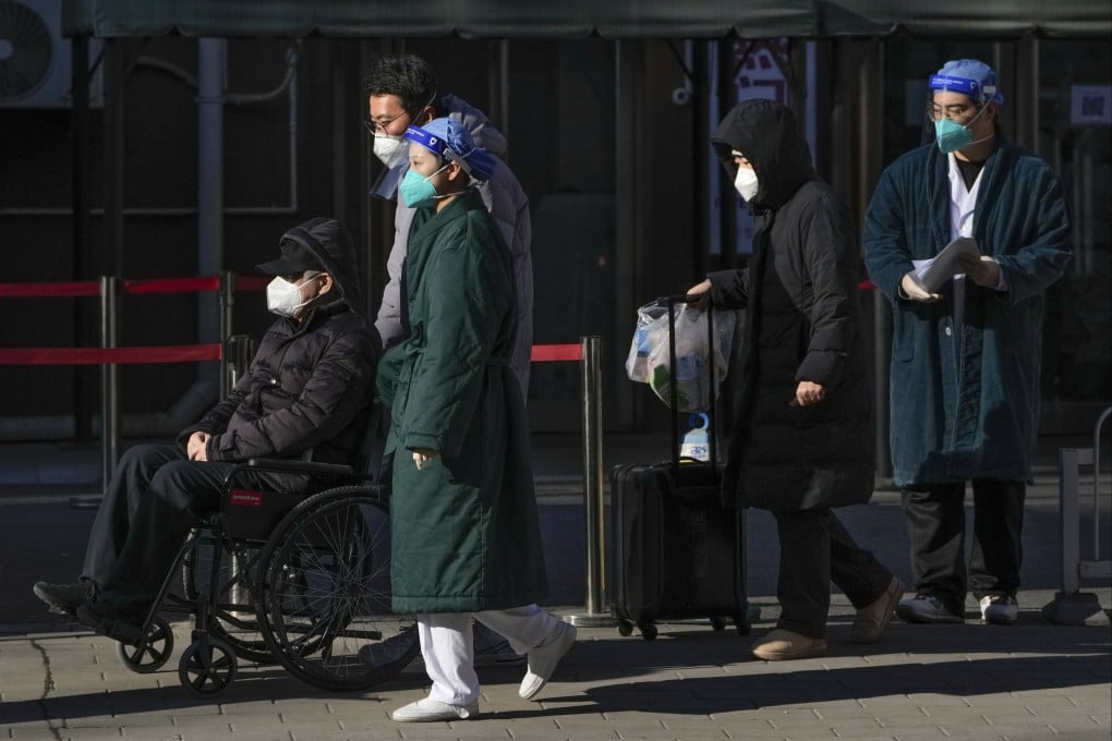 An elderly patient is wheeled out of a fever clinic by members of his family, at a hospital in Beijing. Photo: AP