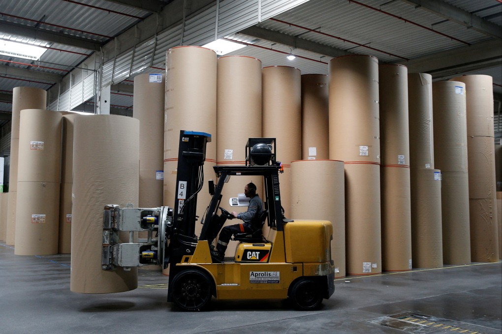 An employee transports a giant reel of paper at the carboard box manufacturing company DS Smith Packaging Atlantique in La Chevroliere, France. Photo: Reuters