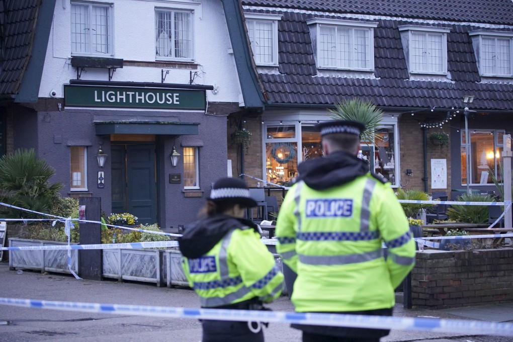 Police officers stand on duty at the Lighthouse Inn in Wallasey Village, near Liverpool, where a Christmas Eve shooting at a pub in northwest England killed a young woman and wounded three men, police said Sunday. Photo: PA via AP