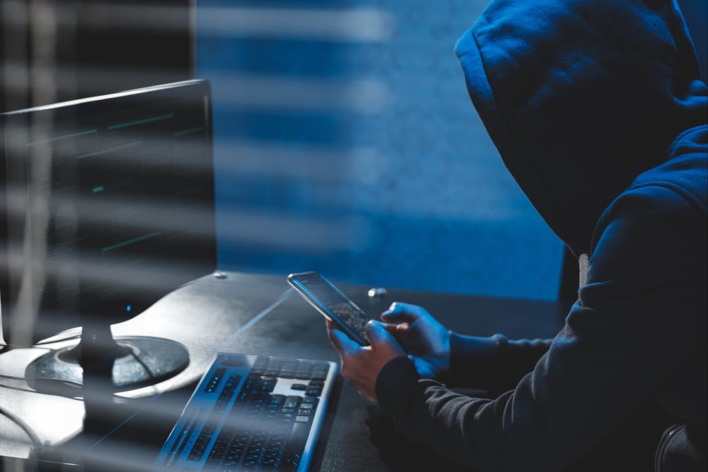 An anonymous hacker uses malware with a mobile phone to hack personal data. Photo: Shutterstock/File