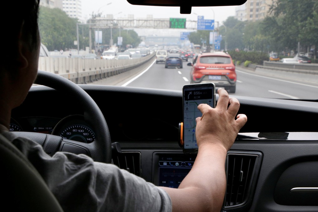 A ride-hailing driver looking at maps direction from a smartphone in Beijing. Photo: Reuters