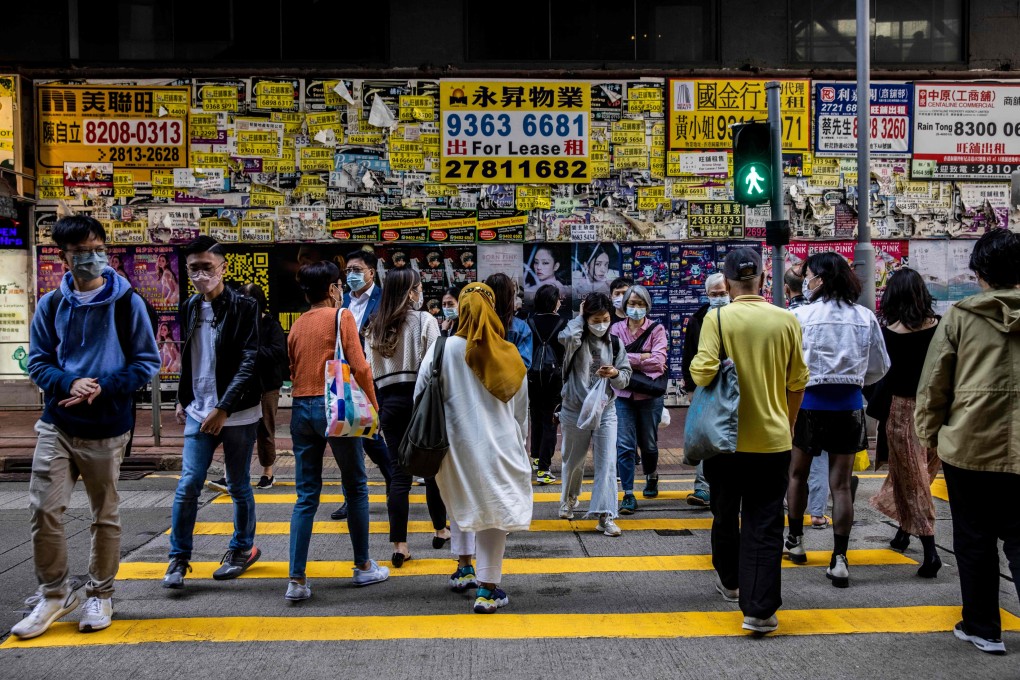Pedestrians cross a road in front of a vacant shop in Hong Kong. Photo: AFP