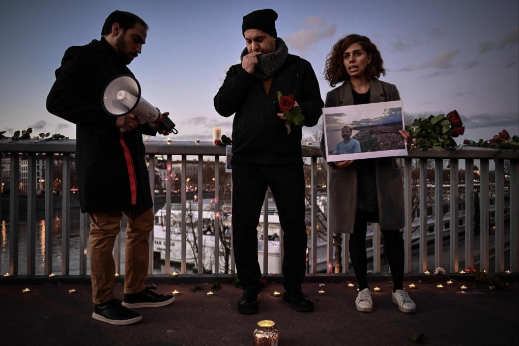 A woman holds a portrait during tribute to Mohammad Moradi, an Iranian man who killed himself after jumping into the Rhone river to raise awareness about the situation of the Iranian people, in Lyon, France on Tuesday. Photo: AFP