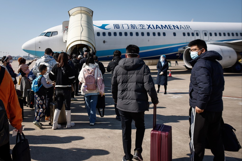Passengers bound for Beijing board a flight at the airport in Xiamen, China’s Fujian province, on December 26. Photo: EPA-EFE