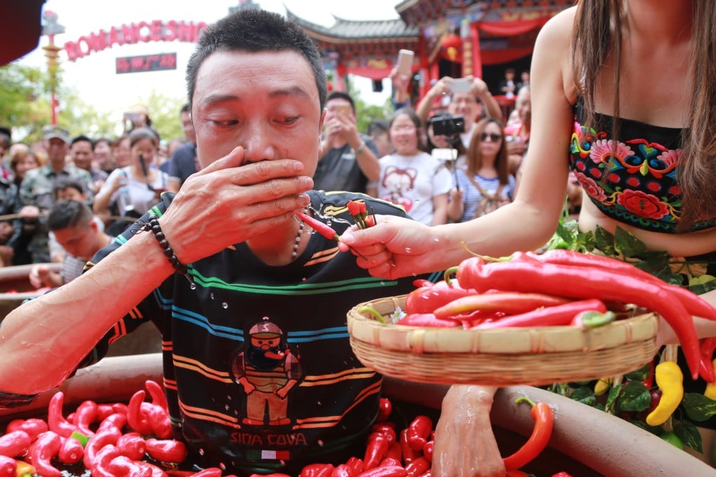 A man eats chillies during an eating competition in Lijiang, Yunnan province in 2016. Experts reveal why some of us love the burn that spice gives us as well as how to build up a tolerance to it. Photo: Getty Images