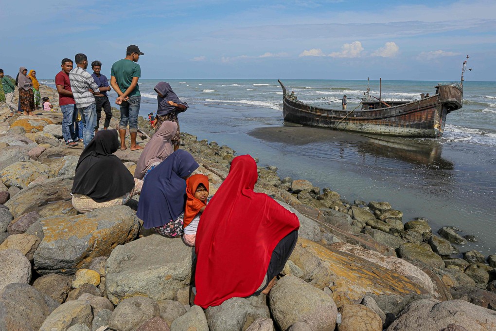 Villagers look at a wooden boat used by Rohingya people in Pidie, Aceh province on December 27, 2022. Photo: AFP