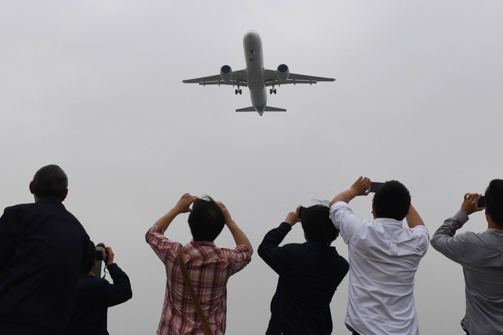 Spectators take photos of a Chinese passenger jet. Malaysia has said it will test the waste water off flights from China for Covid-19, but not the passengers. Photo: AFP
