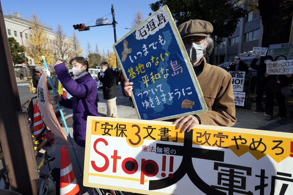 A man holds a placard reading “Stop the military expansion!” participates in a protest near Prime Minister Fumio Kishida’s official residence in Tokyo on December 16. The Japanese government plans to raise taxes to fund an increase in the defence budget. Photo: EPA-EFE