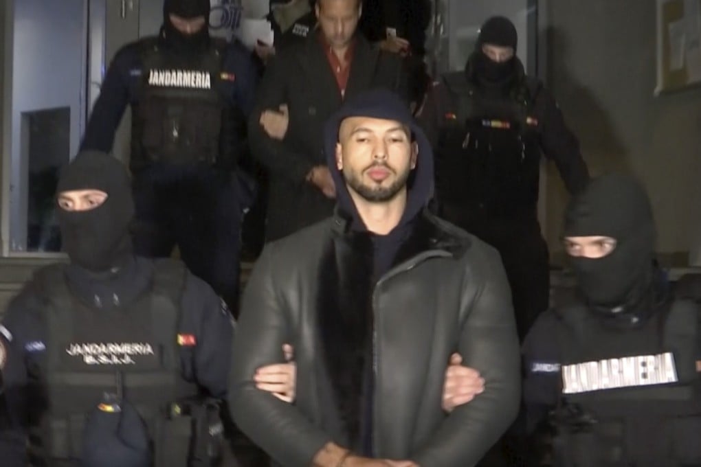 Andrew Tate is led away by police after being arrested in the Ilfov area, north of Bucharest, in Romania on Thursday. Photo: Observator Antena 1 via AP