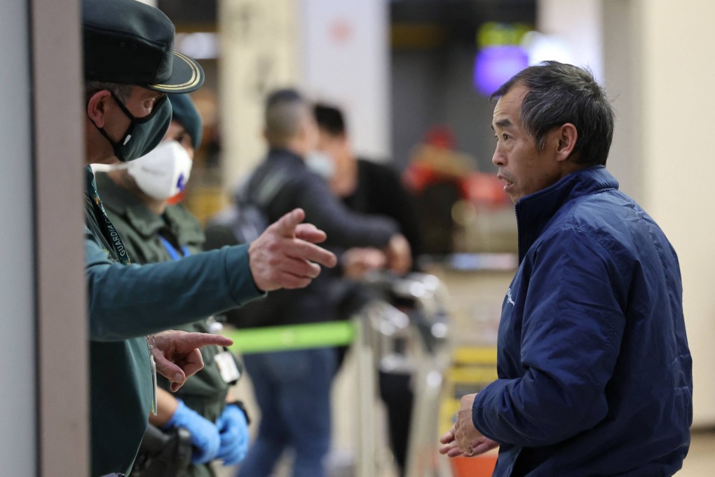 A passenger who arrived on a flight from Beijing listens to indications from a Civil Guard after landing at Spain’s Adolfo Suarez Madrid-Barajas airport on Saturday. Photo: AFP