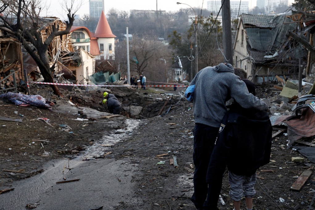 A local resident embraces his son as they stand next to a site of a Russian missile strike, amid Russia’s attack on Ukraine, in Kyiv, Ukraine on December 31, 2022.Photo: Reuters/File