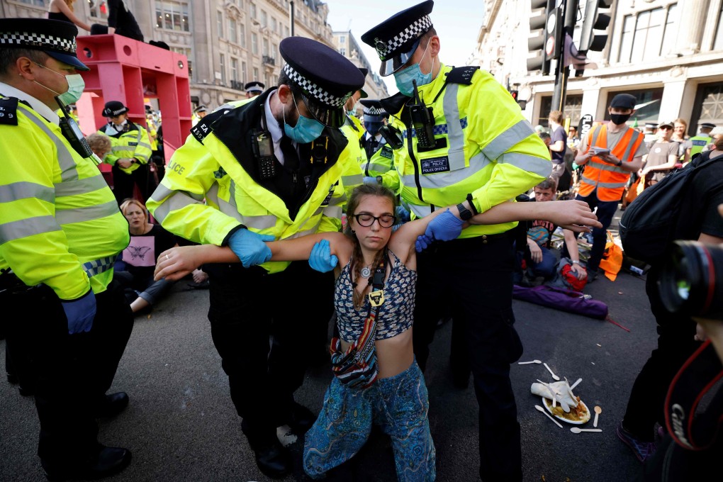 Police officers carry an Extinction Rebellion climate activist during one of the group’s actions in London in August 2021. Photo: AFP