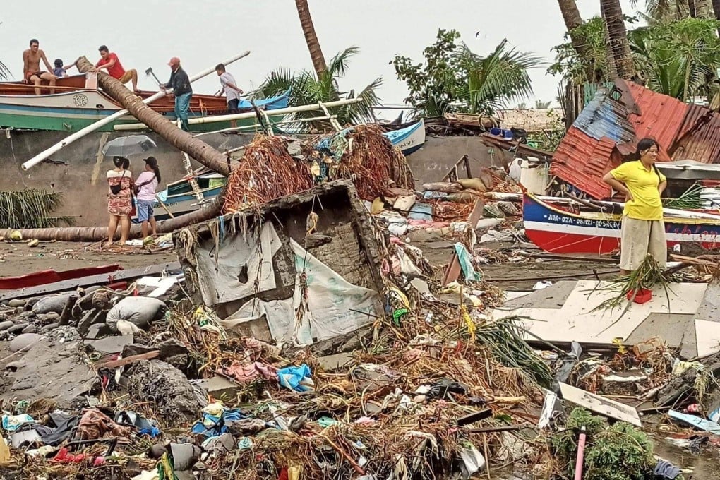 Residents in the Philippines survey the damage caused by heavy rain and floods over Christmas. Photo: Angelica Villarta via AFP