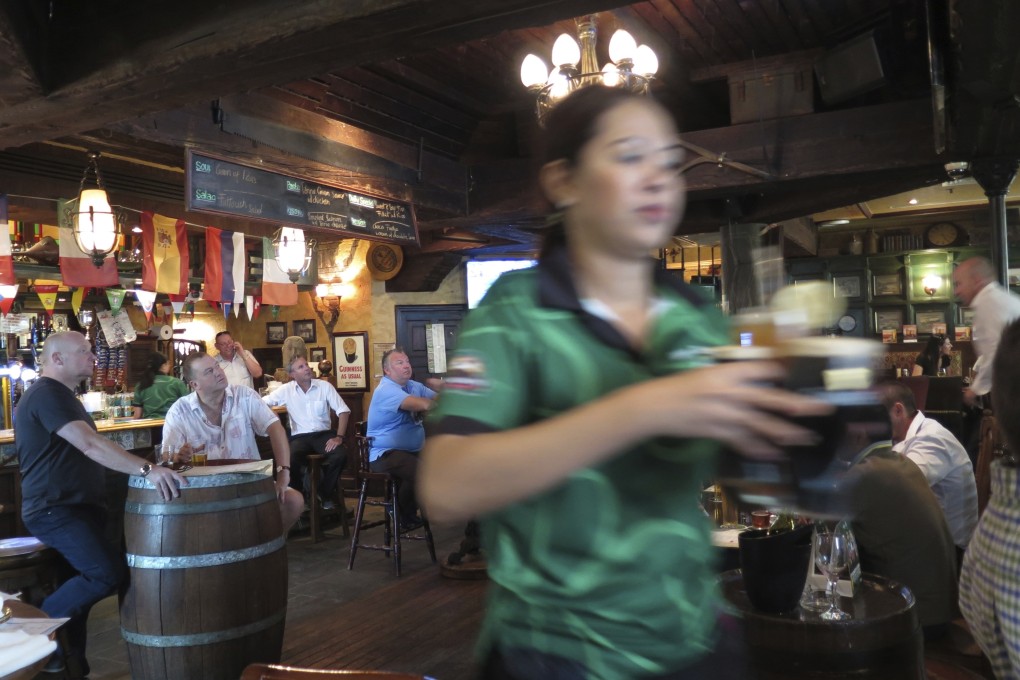 A waitress serves customers beer at a restaurant in Dubai. Dubai ended its 30 per cent tax on alcohol sales in the sheikhdom on January 1 and made its required liquor licenses free to obtain, ending a long-standing source of revenue for its ruling family to apparently further boost its tourism to the emirate. Photo: AP