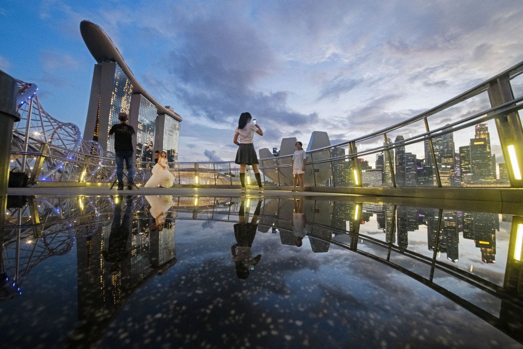 People take photos at Singapore’s Marina Bay last month. The city state’s economic performance is often seen as a useful barometer because of its reliance on trade with the rest of the world. Photo: Xinhua