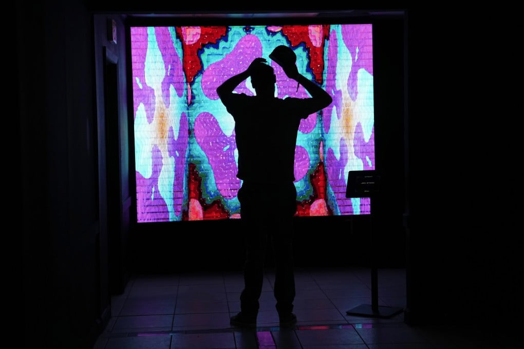 A man looks at an NFT by artist Jen Stark at a festival called The Gateway: A Web3 Metropolis during Miami Art Week on November 30. Photo: AP