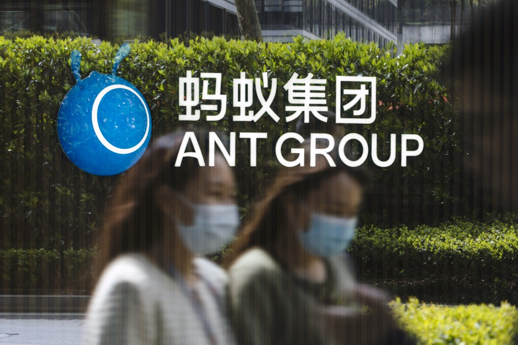 Employees are reflected on a glass panel while walking past a logo at the Ant Group’s headquarters in Hangzhou on March 24, 2021. Photo: Bloomberg.