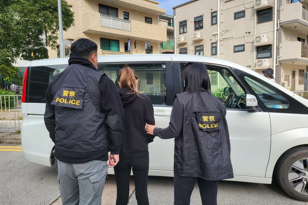 A 26-year-old woman is led away by police after she was arrested in a “guess who I am” phone scam sting operation. Photo: Handout