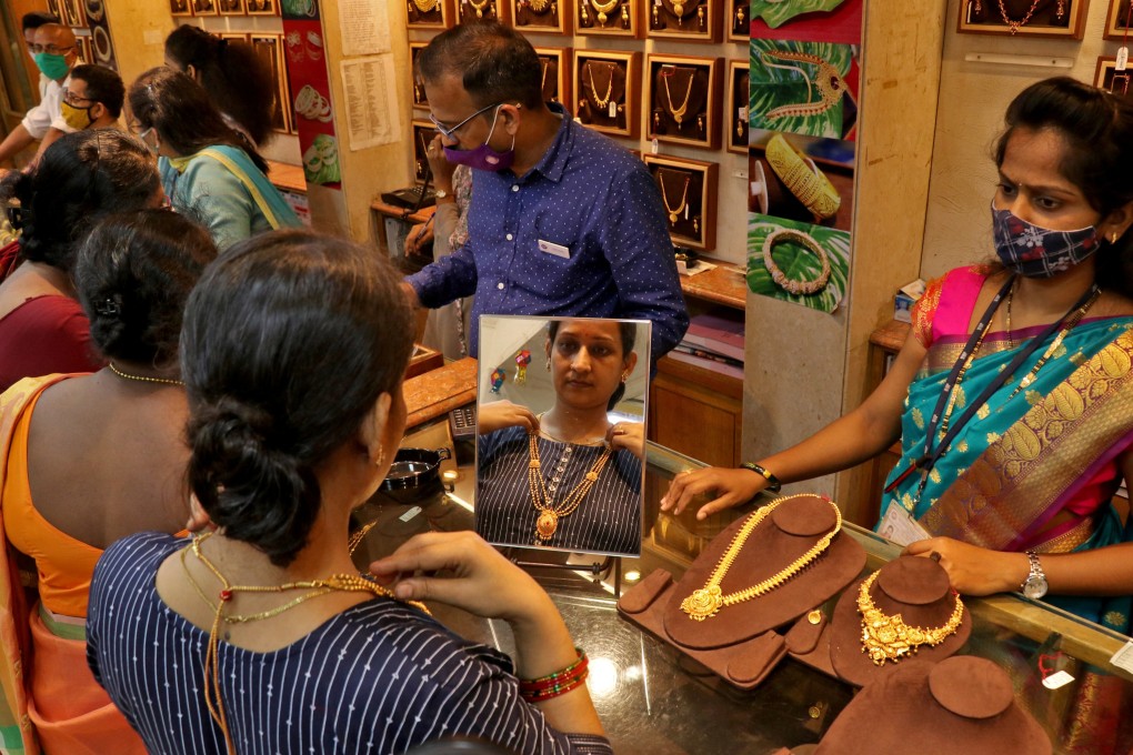 A woman tries on a gold necklace at a jewellery showroom in Mumbai. India’s penchant for gold and high duties makes it a gold smuggling destination. Photo: Reuters