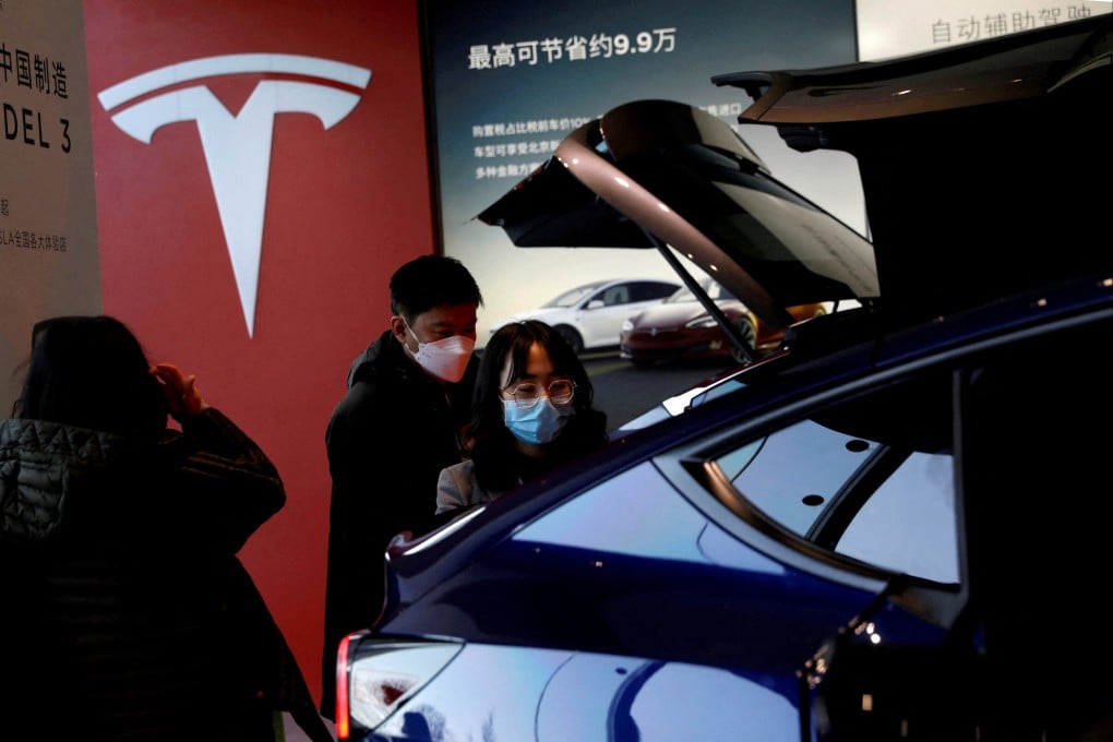 Visitors in front of a Tesla billboard that promised discounts of 99,000 yuan at a showroom in Beijing on January 5, 2021. Photo: Reuters.