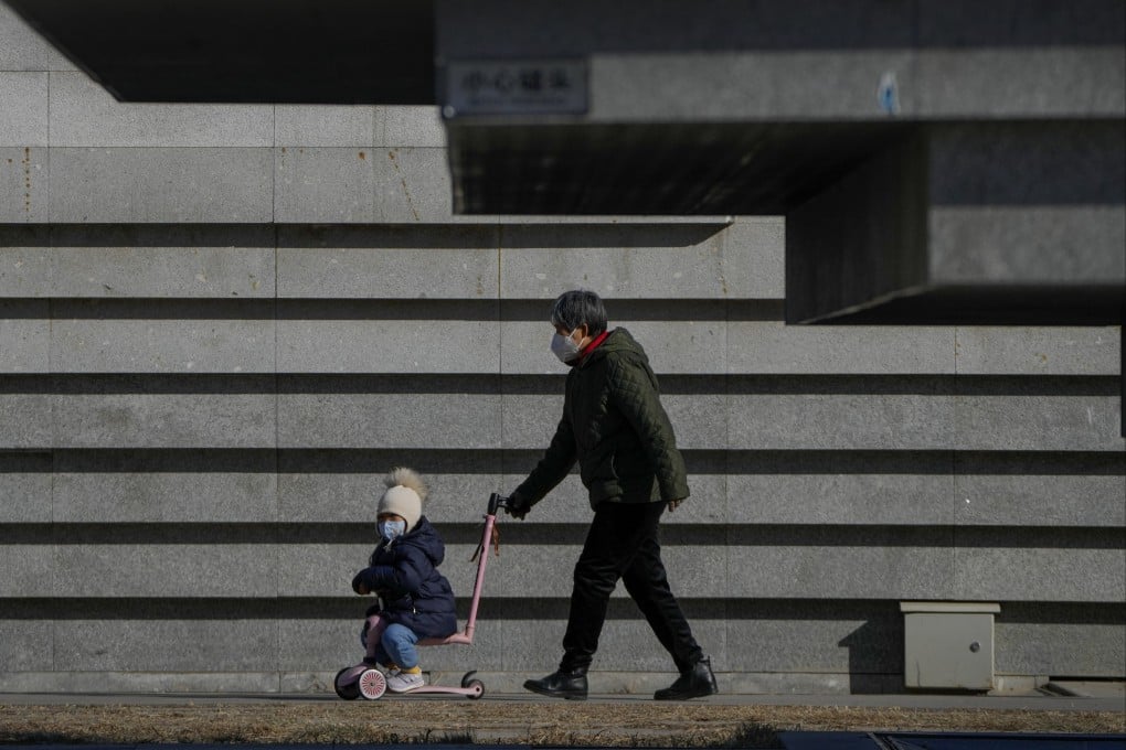 An elderly woman pushes a child on a scooter at a public park in Beijing on December 19. More than 50 per cent of all Chinese grandparents provide care for their grandchildren, compared with around 4 per cent of American grandparents who do. Photo: AP