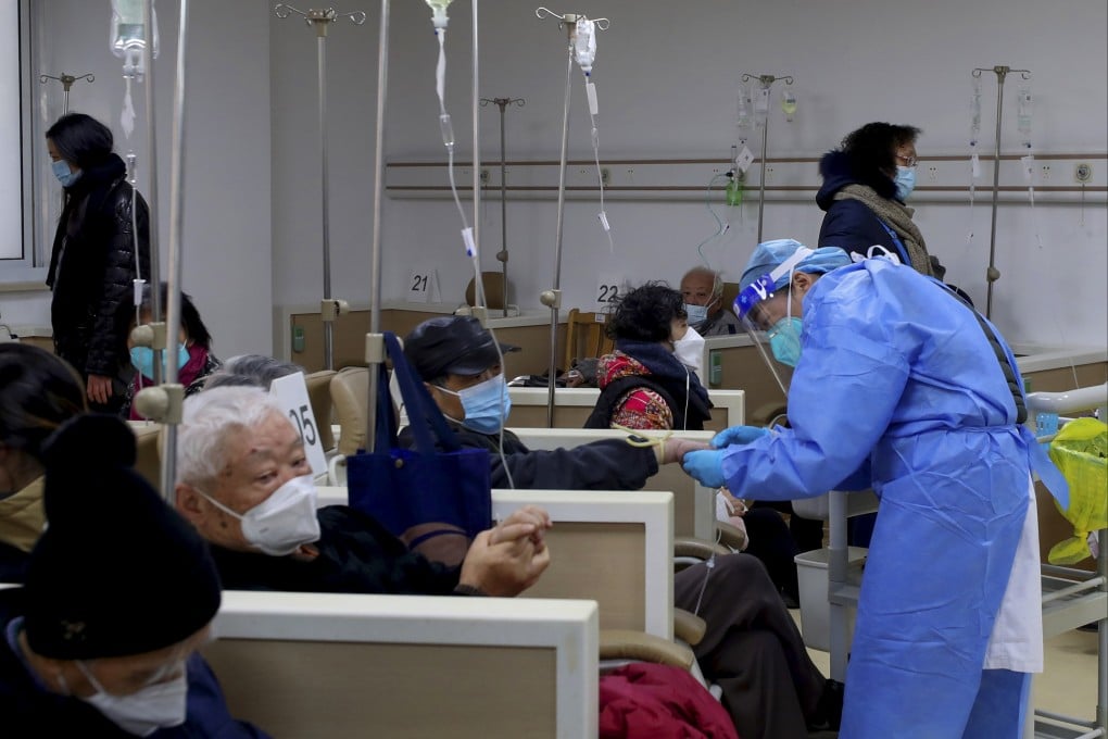A medical worker helps a patient with an intravenous drip at a community healthcare centre in Shanghai as Covid-19 rips through China. Photo: Xinhua via AP